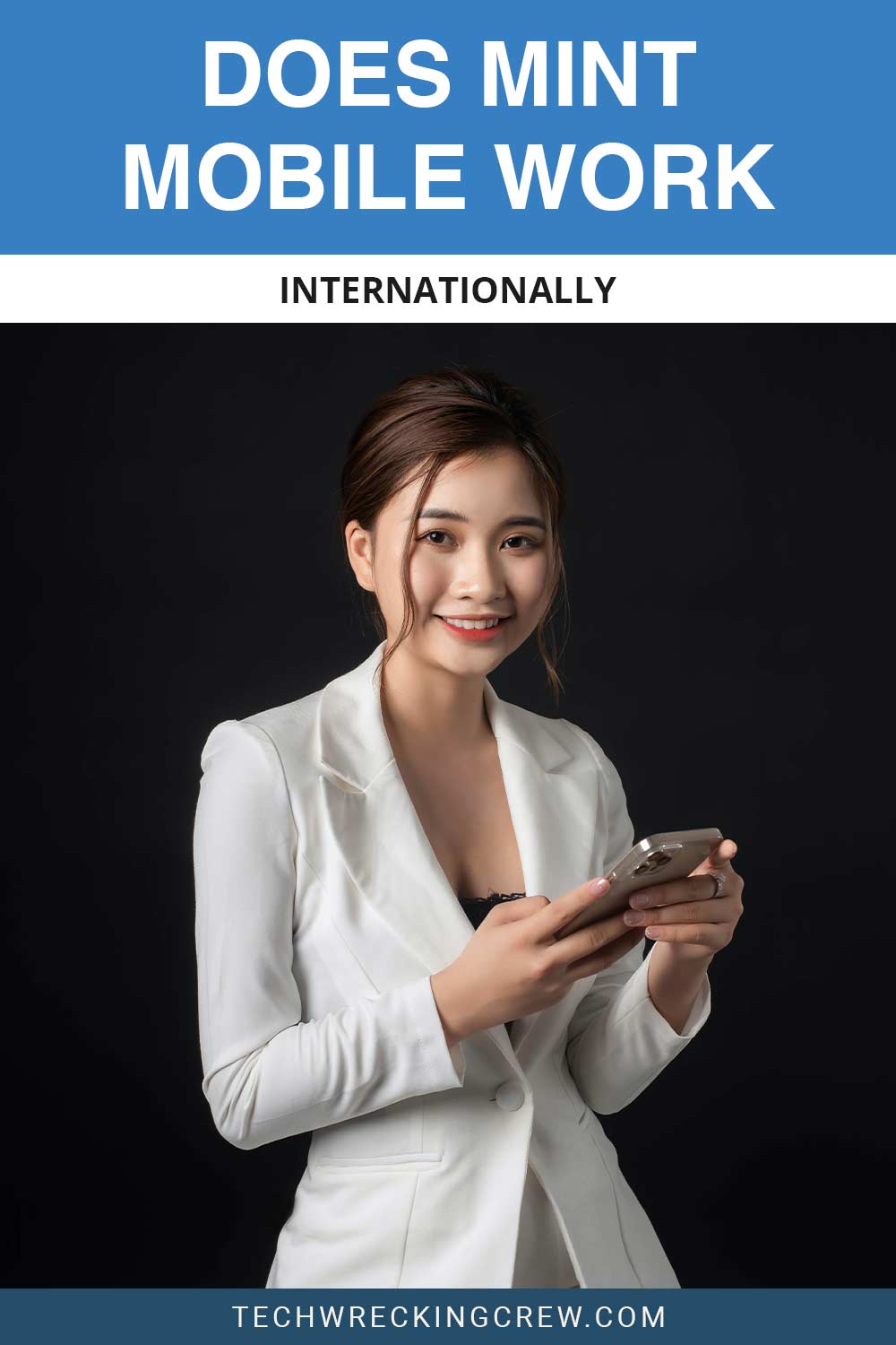 Smiling woman wearing a white suit holding an iphone - Does Mint Mobile Work Internationally?